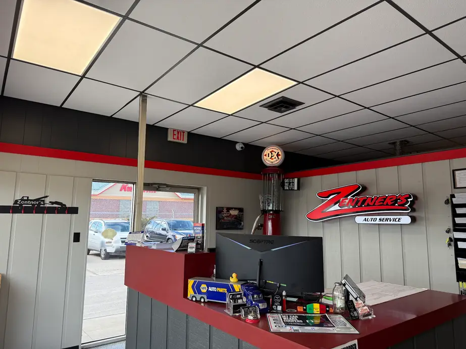 The front counter at Zentner's with the lit red Zentner's Auto Service sign and a vintage D-X gas pump